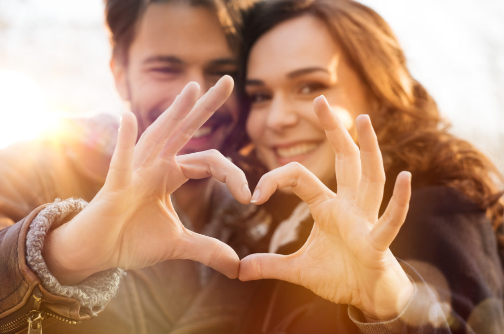 give the gift of love couple forming heart with hands